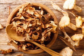 Organic dried chanterelle forest mushrooms close-up on in a wooden bowl. horizontal top view