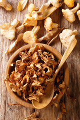 Dry and fresh chanterelle mushrooms close-up on a plate. Vertical top view