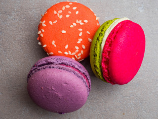 Assorted colorful macaroons falling cookies on grey background