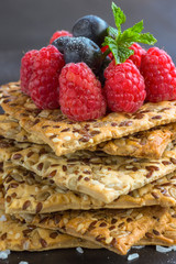 Cookies with whole grains. Raspberry and blueberry berries with icing sugar on top. black background.