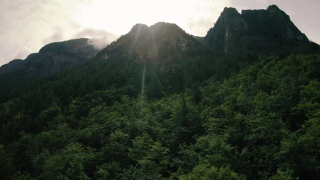 Drone Flying Over Forest Canopy Toward Big Mountain