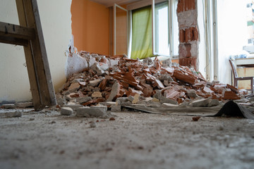 Wall smashed into debris room in apartment ready for renovation with destroyed smashed wall demolish