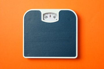 Blue weigh scales on orange background, top view - obrazy, fototapety, plakaty