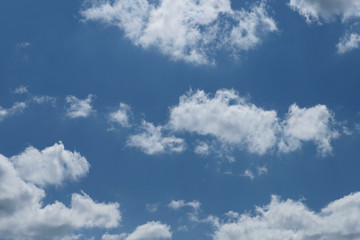 Blue sky background with white clouds. Cropped shot, horizontal, free space. Concept of natural beauty.