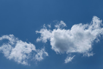 Blue sky background with white clouds. Cropped shot, horizontal, free space. Concept of natural beauty.