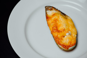 baked mussel on a white plate