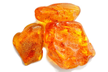Amber. Three pieces of transparent yellow amber on a white background. Sun stone. Natural mineral...