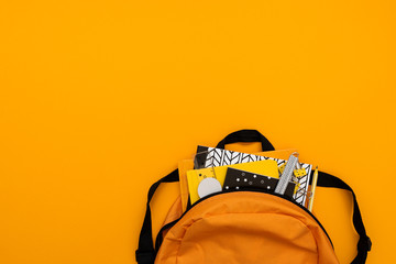 Fototapeta Back to school concept. Backpack with school supplies on yellow background. Top view. Copy space. Flat lay obraz