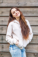 Happy girl smiling. Beauty portrait young happy positive laughing brunette woman on wooden wall...