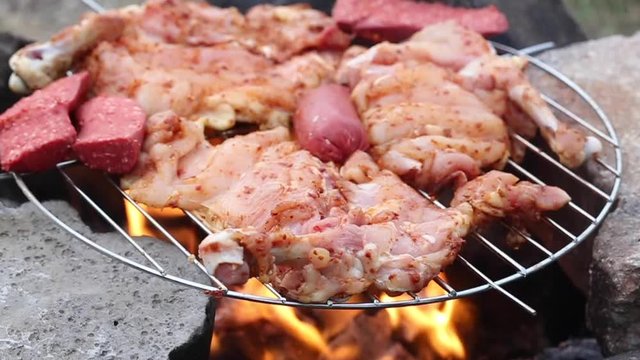 sausage and chicken cooking on a barbecue