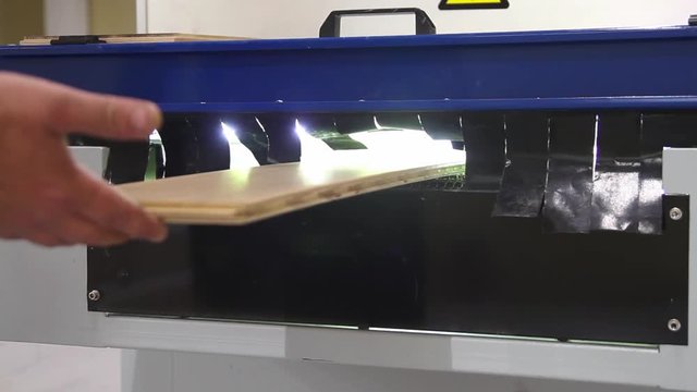 Laminated floor production line. Factory for the production of parquet board. Modern industrial factory. Furniture factory production line. Gluing laminate to a wooden base under pressure and heat.