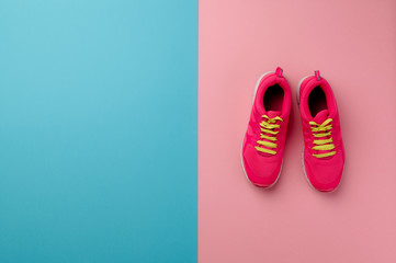 A studio shot of pair of running shoes on pink background. Flat lay.