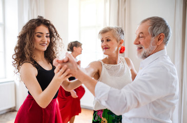 Obraz na płótnie Canvas Group of senior people in dancing class with dance teacher.