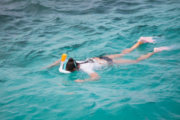 Snorkeling tourist in clear blue water paradise