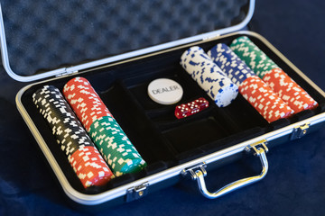 Gambling chips for dealer in open silver metal security briefcase on pool or gamble table.
