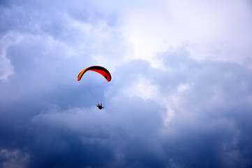 Paraglider flying in the blue sky with beautiful clouds.