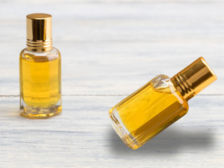 Two bubble with yellow natural aroma oil on white wooden background