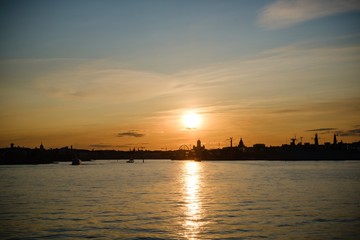 sunset on the sea, city silhouette, golden hour