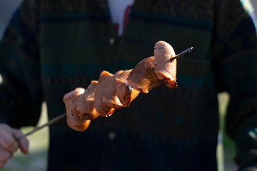 Sausages on wooden skewers, baked on the grill.