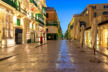 The main city street of the Republic in the light of lanterns at dawn. Valletta. © pillerss