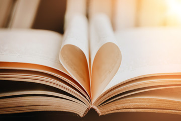 Opened book with heart shaped page. Heart from book page, valentine's day