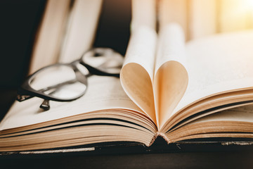 Opened book with heart shaped page. Heart from book page, valentine's day