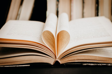 Opened book with heart shaped page. Heart from book page, valentine's day