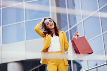 Beautiful girl in a summer city. Lady with shopping bags