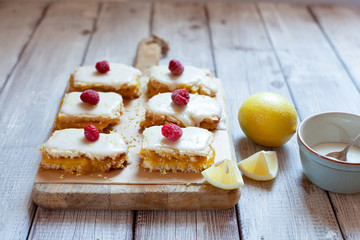 Lemon portion cakes decorated with raspberry and lemon zest