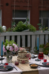 tiered wedding cake with flowers on terrace