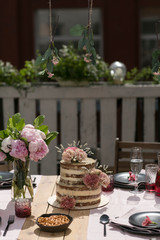 tiered wedding cake with flowers on terrace