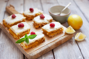 Lemon portion cakes decorated with raspberry and lemon zest