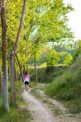 Fototapeta premium Middle-aged woman walking with her dog on a mountain path