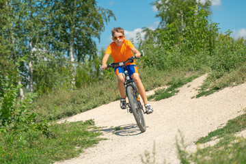 Fototapeta na wymiar Teenager riding a bike in the forest