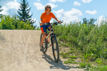 A boy on a mountain bike drives off a hill