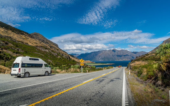 Camper van on side of the road with an amazing view on lake and mountains in New Zealand
