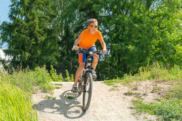 Fototapeta na wymiar A boy on a mountain bike drives off a hill