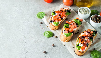 Tomato and cheese fresh made bruschetta. Italian tapas, antipasti with vegetables, herbs and oil on grilled ciabatta and baguette bread. Sandwich.