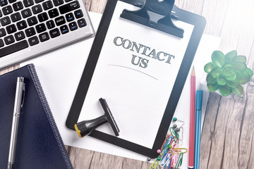 Keyboard with notebook and clipboard on wooden table. Business Concept