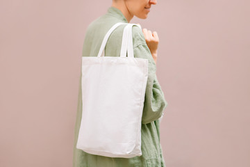 Blank canvas tote bag in female hands. Mockup. Eco friendly concept..