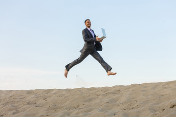 Happy businessman jumping in the air