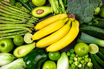 Healthy food clean eating green vegetables and fruits on dark stone background. Healthy food, dieting, detox concept. Top view