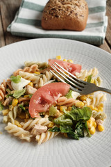 Close-up of tomato and pasta salad on white plate
