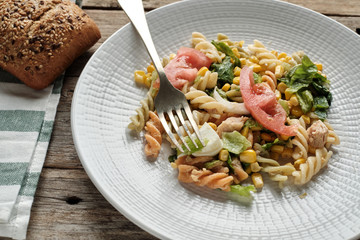 Pasta, tomato, tuna and sweet corn salad on white plate