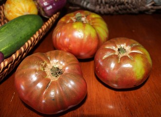 Closeup of Heirloom Tomatoes on Wooden Table and basket, selective focus
