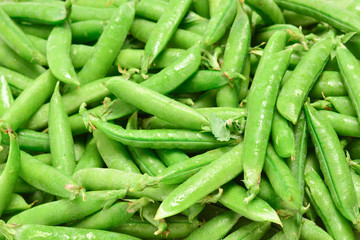 Fresh pea pods as background. Top view.
