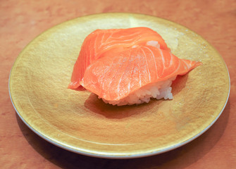 Salmon sushi  (Nigiri Sushi) on gold plate .Delicious Japanese cuisine with rice and raw fish. 