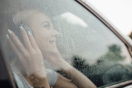 Happy Woman Looking Up Through A Car Window In A Rainy Day, Outdoor