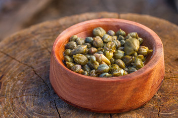 caper in a wood bowl