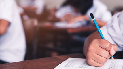 Exam with uniform school student doing educational test with stress in classroom